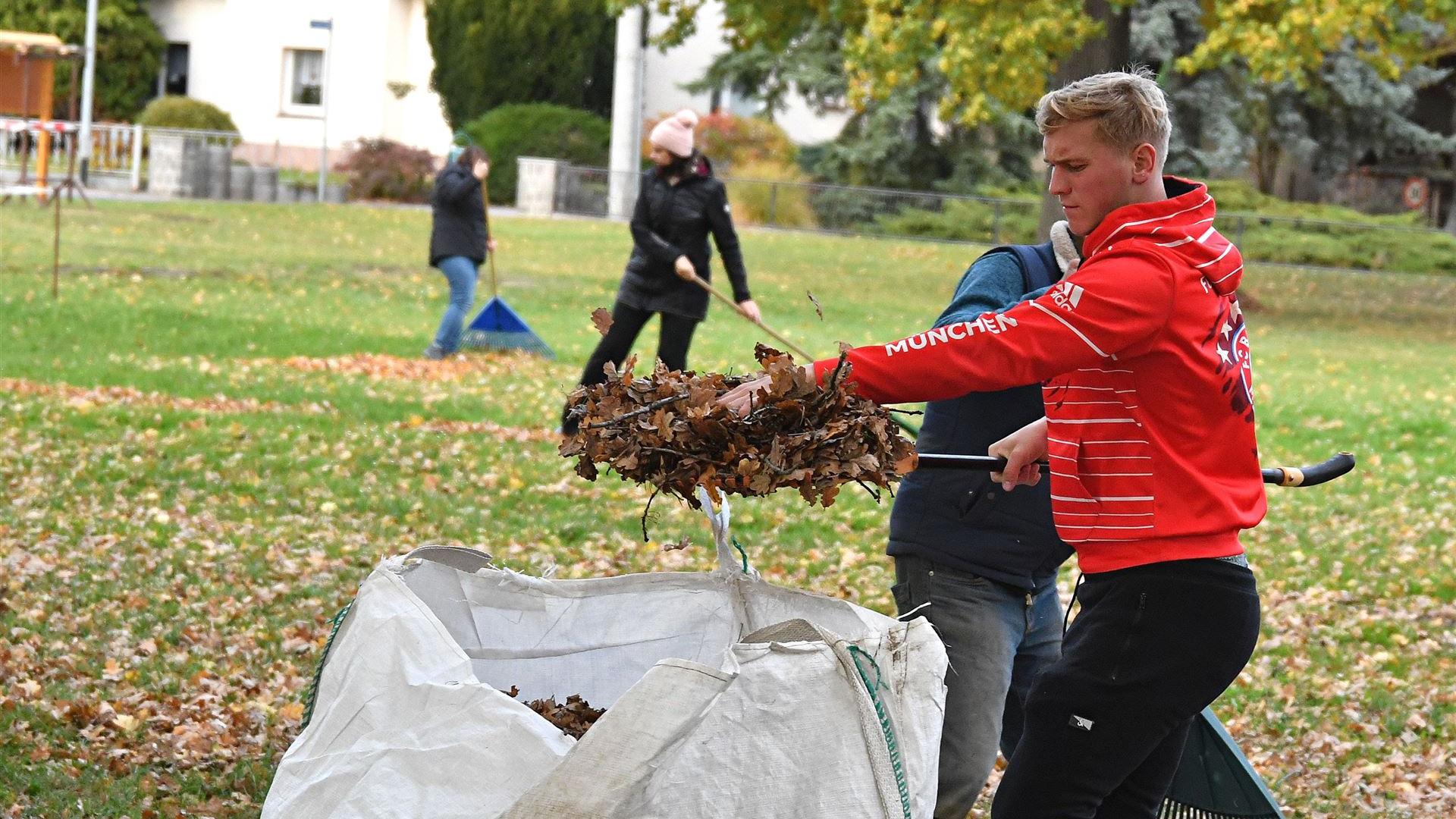 Laub harken zur Spielplatz-Einweihung