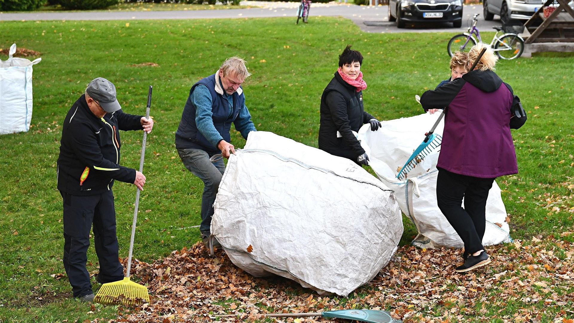 Laub harken zur Spielplatz-Einweihung